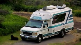 Chinook RV at a coastal campground on a rocky road with a dog